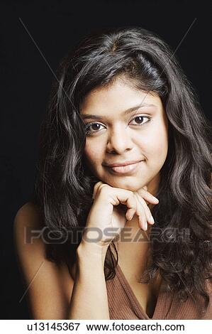 Stock Photo - Portrait of a young woman with her hand on her chin. Fotosearch