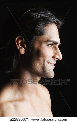 Stock Image - Side profile of a young man smiling. Fotosearch