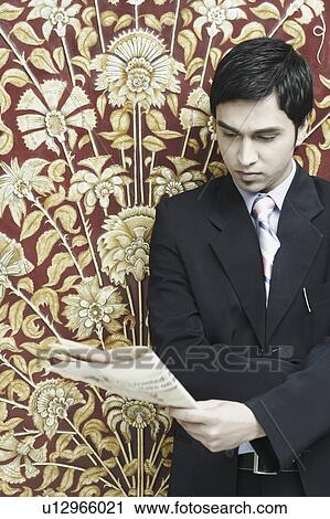 Stock Image - Close-up of a businessman reading a newspaper. Fotosearch
