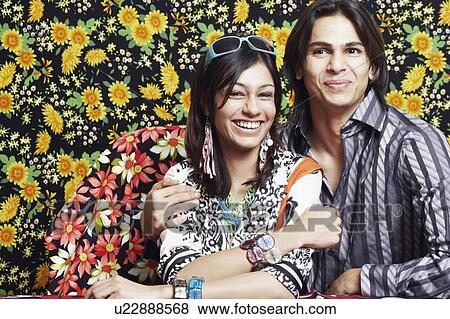 Close-up of a young couple sitting together View Large Photo Image Stock Photo - Close-up of a young couple sitting together. Fotosearch