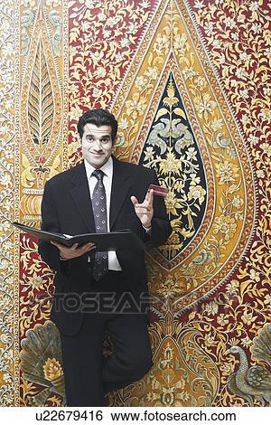 Portrait of a businessman holding a file and a credit card View Large Photo Image Stock Photograph - Portrait of a businessman holding a file and a credit card. Fotosearch