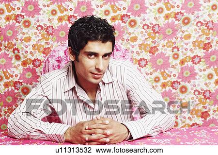 Portrait of a young man sitting with his hands clasped View Large Photo Image Stock Image - Portrait of a young man sitting with his hands clasped. Fotosearch