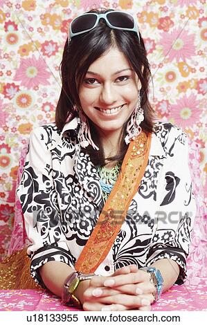 Stock Photography - Portrait of a young woman sitting with her hands clasped. Fotosearch