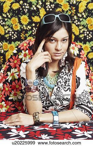 Stock Photo - Portrait of a young woman thinking with her finger on her temple. Fotosearch