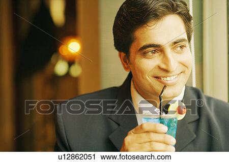 Close-up of a businessman holding a glass of cocktail View Large Photo Image Stock Image - Close-up of a businessman holding a glass of cocktail. Fotosearch
