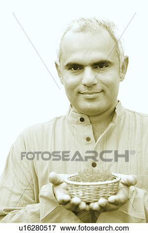Close-up of a mid adult man holding a bowl of flowers View Large Photo Image Stock Photo - Close-up of a mid adult man holding a bowl of flowers. Fotosearch