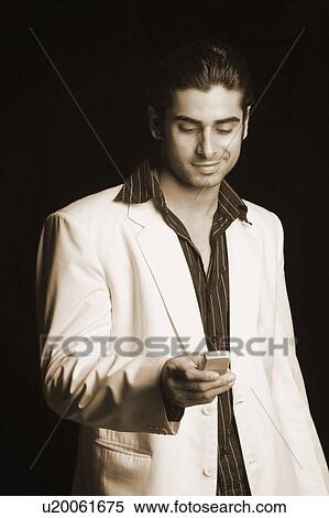 Close-up of a young man operating a mobile phone View Large Photo Image Stock Photography - Close-up of a young man operating a mobile phone. Fotosearch