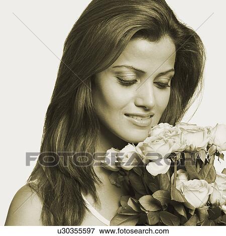 Close-up of a young woman holding a bouquet of flowers View Large Photo Image Stock Photo - Close-up of a young woman holding a bouquet of flowers. Fotosearch