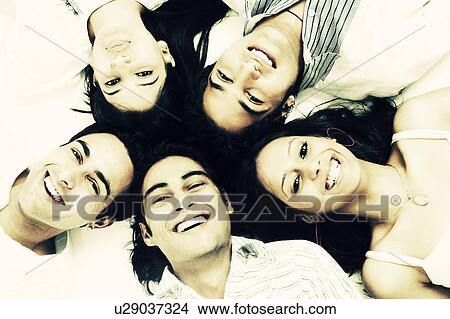 Picture - Close-up of three young men and two young women lying down. Fotosearch
