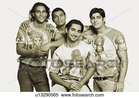 Portrait of a young man sitting with his friends standing behind him and smiling View Large Photo Image Stock Photography - Portrait of a young man sitting with his friends standing behind him and smiling. Fotosearch