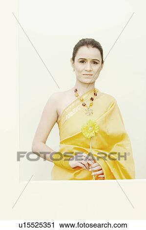 Stock Image - Portrait of a young woman holding a flower. Fotosearch
