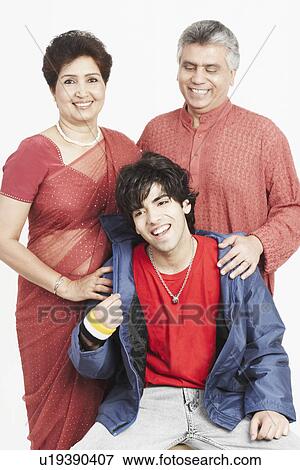 Close-up of a mature couple and their son smiling View Large Photo Image Stock Photo - Close-up of a mature couple and their son smiling. Fotosearch