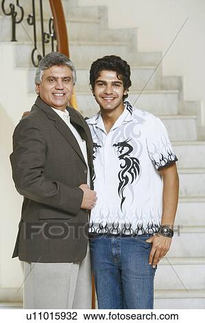 Stock Image - Portrait of a mature man and his son smiling. Fotosearch