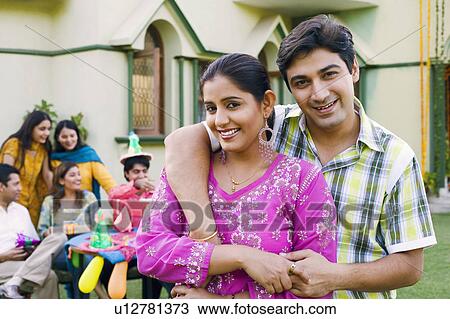 Stock Image - Portrait of a young man embracing a young woman and smiling. Fotosearch