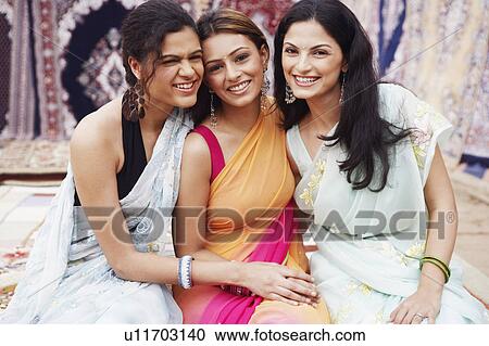 Stock Image - Portrait of three young women smiling. Fotosearch