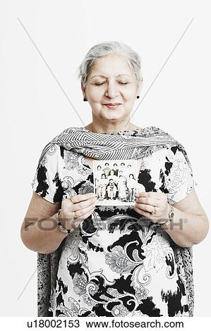 Stock Image - Close-up of a mature woman holding a photograph. Fotosearch