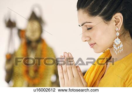 Close-up of a young woman praying View Large Photo Image Stock Image - Close-up of a young woman praying. Fotosearch