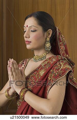 Close-up of a young woman praying View Large Photo Image Stock Photo - Close-up of a young woman praying. Fotosearch