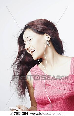 Close-up of a young woman with her eyes closed listening to an MP3 player View Large Photo Image Picture - Close-up of a young woman with her eyes closed listening to an MP3 player. Fotosearch