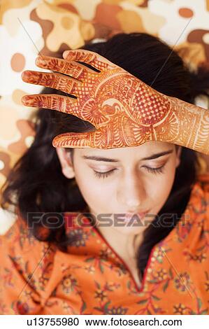 Close-up of a young woman with her henna tattooed hand on her forehead View Large Photo Image Stock Image - Close-up of a young woman with her henna tattooed hand on her forehead. Fotosearch