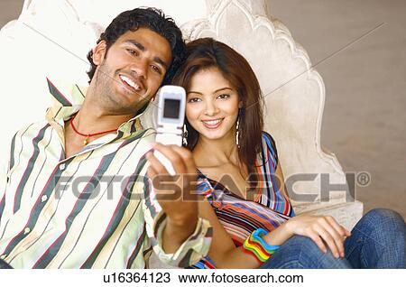 High angle view of a young couple taking a photograph of themselves View Large Photo Image Stock Image - High angle view of a young couple taking a photograph of themselves. Fotosearch