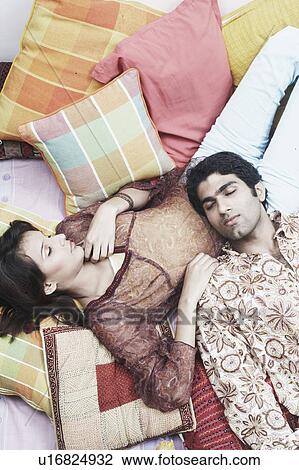 Stock Image - High angle view of a young man lying on a woman's lap. Fotosearch