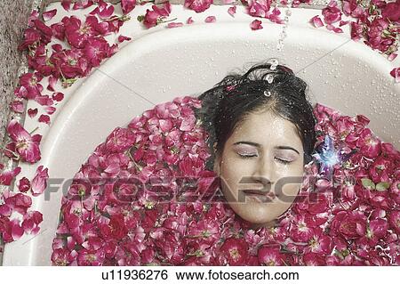 High angle view of a young woman lying in a bathtub covered with flower petals View Large Photo Image Stock Photograph - High angle view of a young woman lying in a bathtub covered with flower petals. Fotosearch