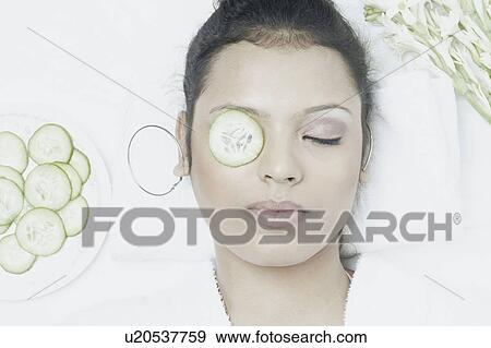 High angle view of a young woman with a cucumber slice on her eye View Large Photo Image Stock Photo - High angle view of a young woman with a cucumber slice on her eye. Fotosearch