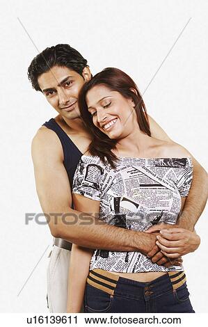 Portrait of a young man embracing a young woman from behind View Large Photo Image Stock Image - Portrait of a young man embracing a young woman from behind. Fotosearch