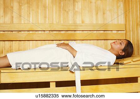Stock Photography - Side profile of a young woman lying in a sauna. Fotosearch