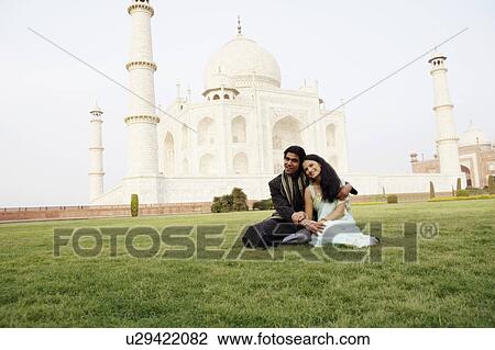 Young couple sitting in front of a mausoleum, Taj Mahal, Agra, Uttar Pradesh, India View Large Photo Image Stock Image - Young couple sitting in front of a mausoleum, Taj Mahal, Agra, Uttar Pradesh, India. Fotosearch