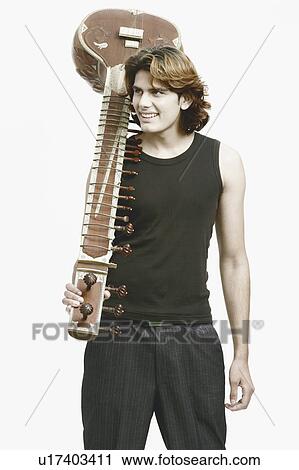 Stock Image - Close-up of a male musician holding a sitar. Fotosearch