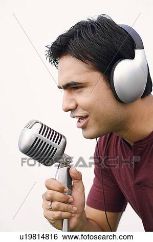 Stock Photograph - Close-up of a young man singing into a microphone. Fotosearch