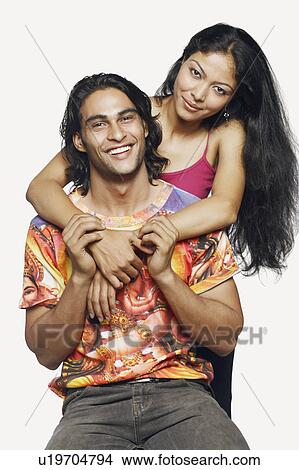 Picture - Portrait of a mid adult woman embracing a young man from behind. Fotosearch