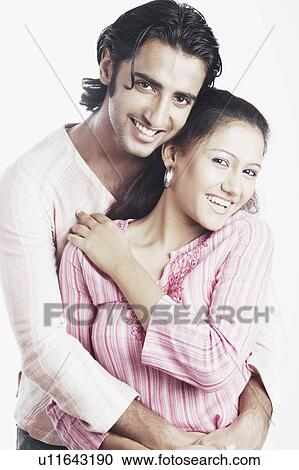 Stock Image - Portrait of a young man embracing a young woman. Fotosearch