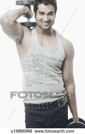 Portrait of a young man exercising with dumbbells View Large Photo Image Stock Photo - Portrait of a young man exercising with dumbbells. Fotosearch