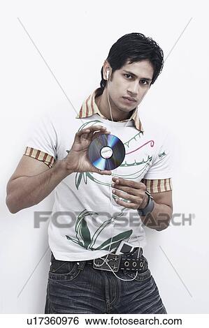 Portrait of a young man holding a CD and listening to music View Large Photo Image Stock Photograph - Portrait of a young man holding a CD and listening to music. Fotosearch
