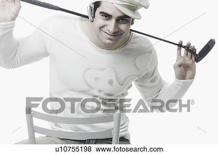 Portrait of a young man holding a golf club on his shoulders View Large Photo Image Stock Photo - Portrait of a young man holding a golf club on his shoulders. Fotosearch
