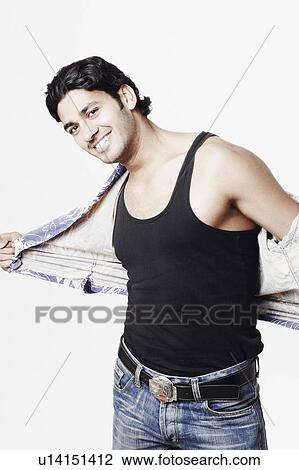 Stock Image - Portrait of a young man holding his unbuttoned shirt. Fotosearch