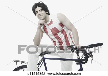 Portrait of a young man sitting on a bicycle View Large Photo Image Stock Image - Portrait of a young man sitting on a bicycle. Fotosearch