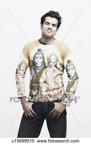 Stock Image - Portrait of a young man standing with his hands in his pockets. Fotosearch