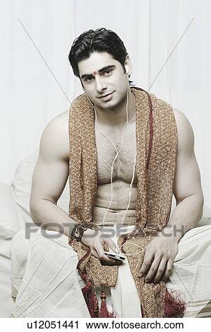 Portrait of a young man wearing traditional clothing listening to an MP3 player View Large Photo Image Stock Image - Portrait of a young man wearing traditional clothing listening to an MP3 player. Fotosearch