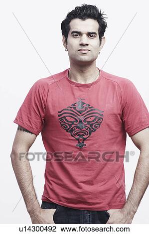 Stock Image - Portrait of a young man with his hands in his pockets. Fotosearch