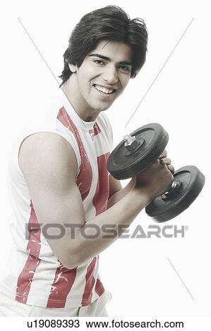 Side profile of a young man exercising with a dumbbell View Large Photo Image Stock Image - Side profile of a young man exercising with a dumbbell. Fotosearch