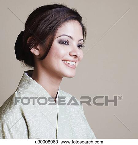Stock Image - Close-up of a young woman wearing a kimono and smiling. Fotosearch