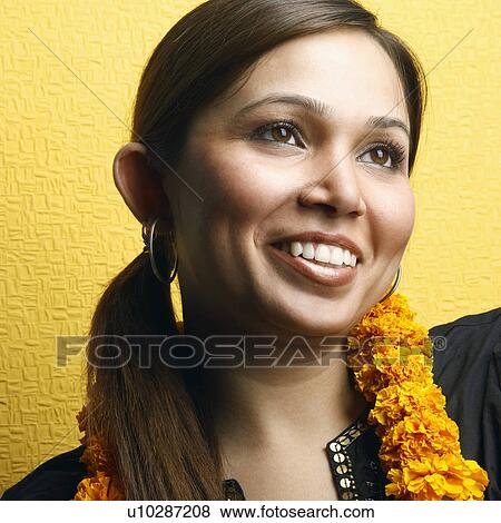 Close-up of a young woman wearing a garland View Large Photo Image Stock Photo - Close-up of a young woman wearing a garland. Fotosearch