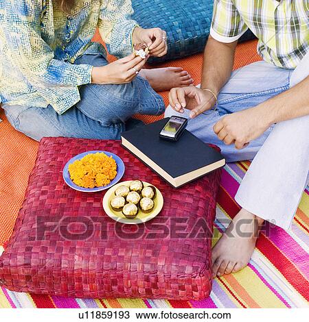 Stock Image - Low section view of a man and a woman at a picnic. Fotosearch