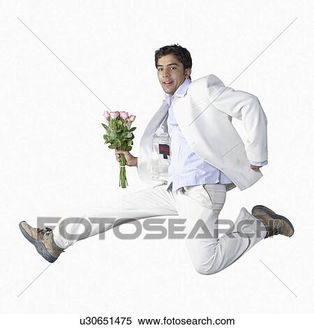 Portrait of a young man jumping and holding a bunch of flowers View Large Photo Image Stock Photography - Portrait of a young man jumping and holding a bunch of flowers. Fotosearch