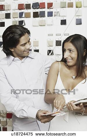 Close-up of a young couple choosing fabric swatches from a magazine View Large Photo Image Stock Photography - Close-up of a young couple choosing fabric swatches from a magazine. Fotosearch