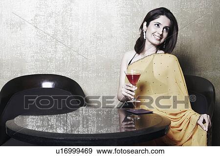Close-up of a young woman holding a martini glass View Large Photo Image Stock Photo - Close-up of a young woman holding a martini glass. Fotosearch